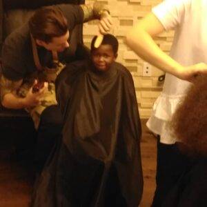 Image shows a child wearing a cape receiving a haircut, potentially symbolizing vulnerability and the need for protection in personal injury cases in Las Vegas.