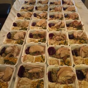 Rows of prepared meals including turkey, beets, corn, green beans, and mashed potatoes, showing the Las Vegas law firm's commitment to serving the community.