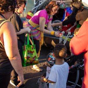 Image shows people participating in a Trunk or Treat event, possibly organized or supported by a personal injury law firm in Las Vegas.