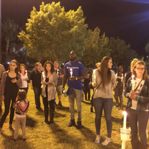 A nighttime photo shows a diverse group of people holding candles during a vigil in Las Vegas, symbolizing remembrance and community support following a personal injury incident, highlighting the importance of legal assistance during challenging times.