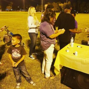 People gathered at a community event, with a table set up, indicating a commitment to the Las Vegas community and potential legal support for personal injury cases.
