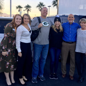 A group of six people, presumably attorneys or staff, are smiling and standing in front of a white Mercedes-Benz SUV in Las Vegas, suggesting the firm's connection to auto accidents and personal injury cases.