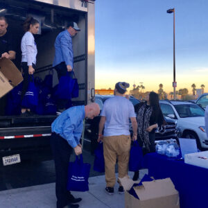 Community outreach event in Las Vegas, Nevada, featuring volunteers unloading boxes and bags from a truck with the firm's branding, symbolizing their commitment to supporting the community and providing personal injury legal services.