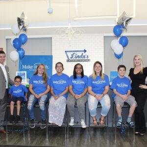 Las Vegas Personal Injury Law Firm shows commitment to community, supporting Make-A-Wish with a group photo featuring lawyers and Make-A-Wish participants in a bright, welcoming setting with balloons and "Linda's Wishing Counter" signage.
