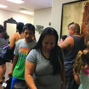 Image shows people inside a Las Vegas law firm, possibly waiting for a personal injury consultation, featuring diverse individuals and families.