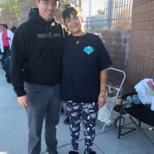 A male attorney with "Vegas Born" hoodie has his arm around a smiling female client; representing a personal injury case and highlighting community support in Las Vegas.