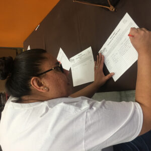 Close-up of a woman filling out a form for "Three Square" and "Black Mountain Lions Club," highlighting a Las Vegas personal injury law firm's community engagement.