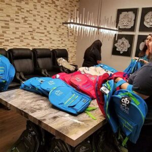 Law firm staff in Las Vegas organizing colorful backpacks on a marble table for a community outreach program related to personal injury.