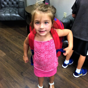 Young girl with a backpack looking at the camera, suggesting the potential for accidents and the need for personal injury protection.