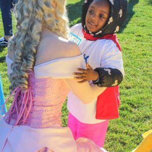 A young child with a Mickey Mouse hat embraces a princess on a sunny day, representing the innocence and future we strive to protect through diligent personal injury law services in Las Vegas.