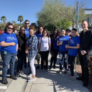 Group photo of the "Paul, More Lawyer, Less Fee" Personal Injury Law Firm team in Las Vegas, posing outdoors on a sunny day.