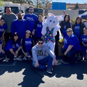 A group of people, including the Easter Bunny, gather for a community event hosted by a Las Vegas personal injury law firm, showcasing their commitment to the local community.