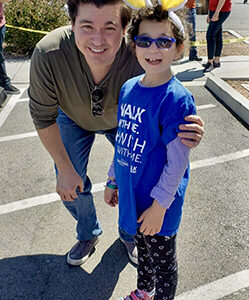 A man and child with bunny ears pose at a community event, reflecting the Las Vegas law firm's commitment to supporting local initiatives related to children and injury awareness.