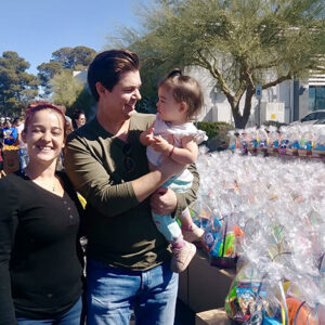 A family stands in front of Easter baskets at a Las Vegas community event hosted by a personal injury law firm.