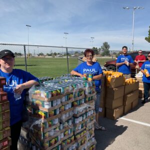 Volunteers from a Las Vegas personal injury law firm donate canned goods, juice, and cereal boxes to a local food drive, supporting the community.