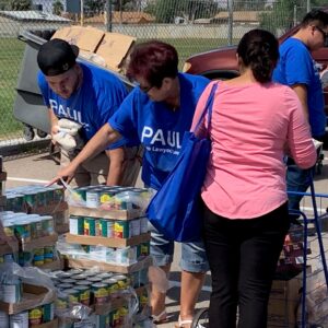 Volunteers from a Las Vegas personal injury law firm distribute canned goods and other food items at a local charity event, showcasing their commitment to community service.