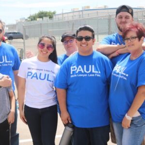 A group of diverse people wearing branded shirts that say "More Lawyer. Less Fee. PAUL.", representing a Las Vegas personal injury law firm.