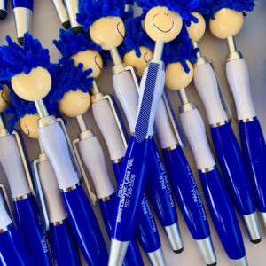 A close-up image of blue and white pens with smiley face toppers, promoting a Las Vegas personal injury law firm, "Paul More Lawyer. Less Fee." and phone number 702-728-5500.