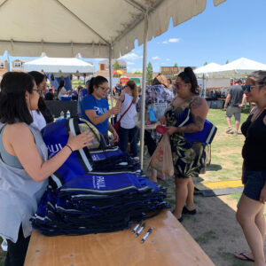 Promotional image of the "Paul" Law Firm booth at an outdoor event in Las Vegas, offering branded tote bags and pens to attendees; the Law Firm specializes in personal injury cases.