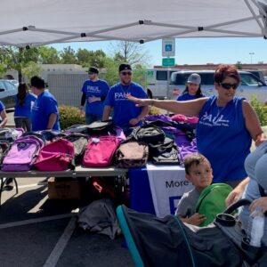 Personal injury law firm volunteers giving away free backpacks to families in Las Vegas.