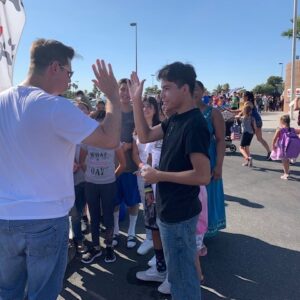 Image shows a lawyer high-fiving a youth at a public event in Las Vegas, symbolizing community engagement and legal support for personal injury cases.