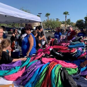 A community outreach event by a Las Vegas personal injury law firm shows volunteers handing out backpacks to families, highlighting the firm's commitment to community support and legal services after accidents.