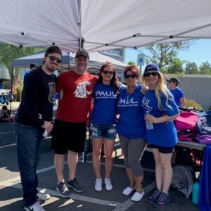 A group of people stand under a canopy in Las Vegas, wearing matching blue shirts with the text "PAUL. More Lawyer, Less Fees.", suggesting a law firm focused on personal injury cases.
