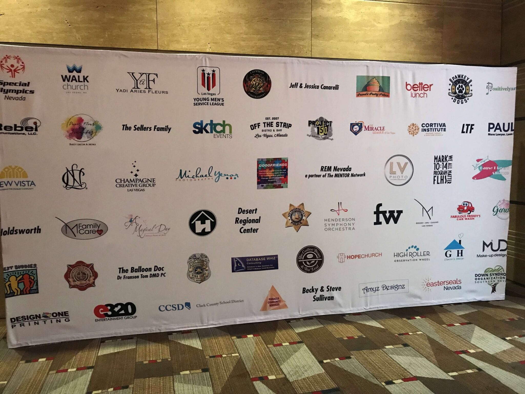 A backdrop featuring a variety of Las Vegas businesses and organizations, showcasing community support and potential partners for a personal injury law firm.