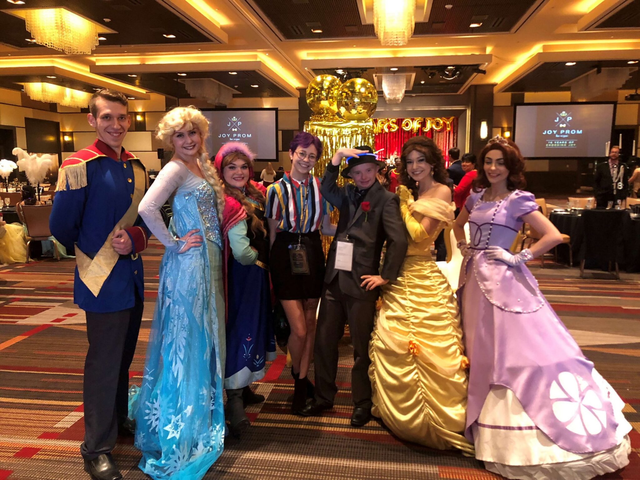 A group of joyful attendees in Las Vegas at the Joy Prom event, dressed in vibrant costumes, potentially injured through negligence, and seeking justice in personal injury claims.
