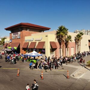 A large crowd gathers outside a Party USA store in Las Vegas, possibly indicating an event or promotion, with potential implications for public safety and the need for legal counsel in case of injuries.