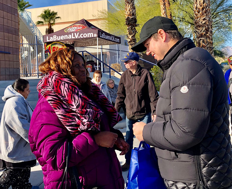 Image shows a man speaking to a woman outdoors, potentially offering legal assistance related to personal injury claims in Las Vegas.