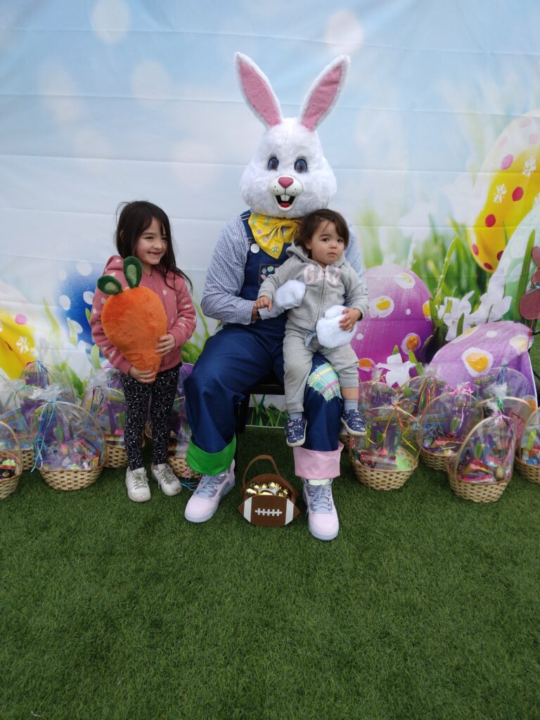 Easter celebration photo featuring the Easter Bunny with two young girls and baskets of treats, possibly for a Personal Injury Law Firm in Las Vegas focused on community engagement and family-friendly events.