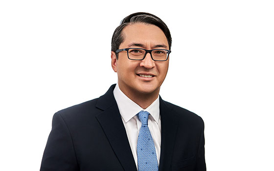 Professional headshot of a personal injury attorney in Las Vegas wearing glasses and a blue tie
