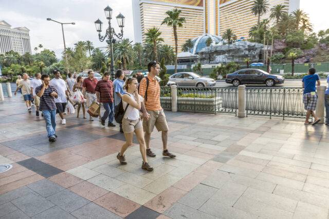 Crowded sidewalk scene in Las Vegas, highlighting pedestrian traffic near a busy street with cars, representing potential risks and need for personal injury lawyers.