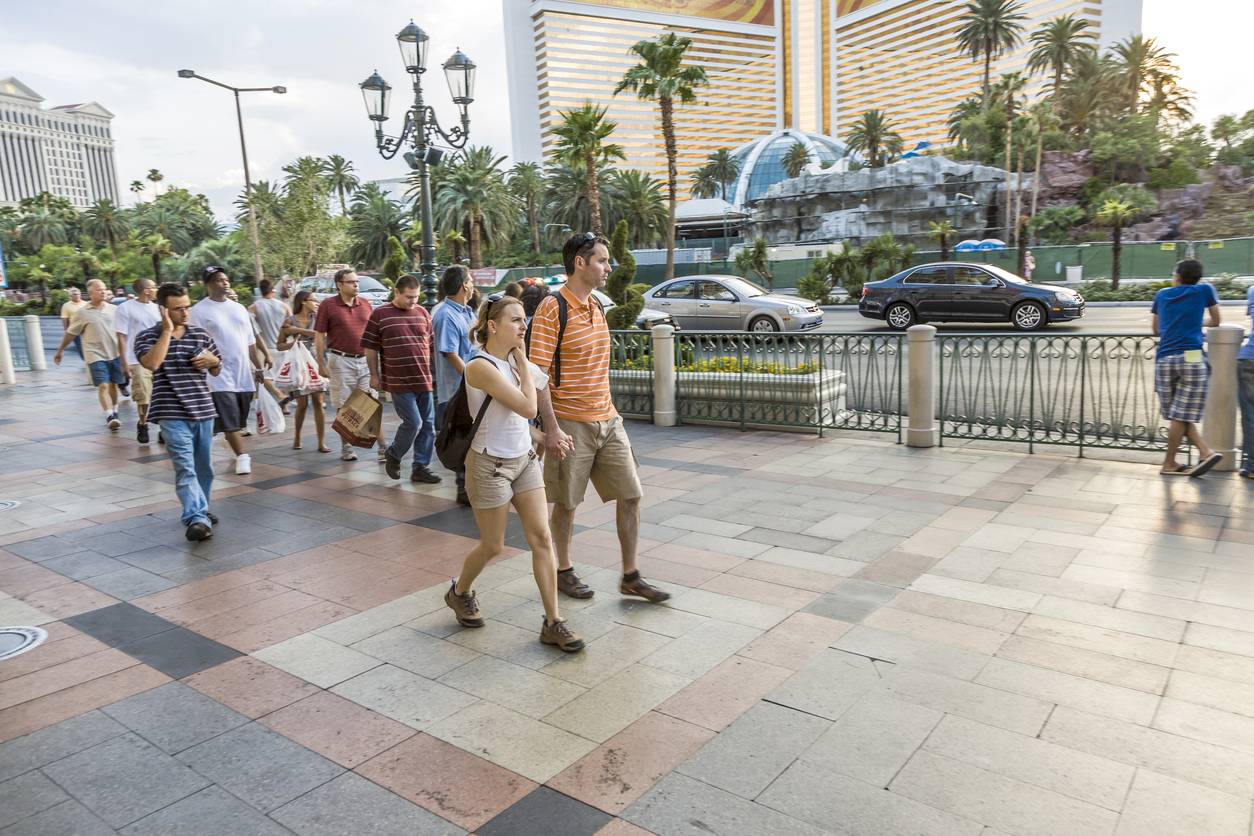 Crowded sidewalk scene in Las Vegas, highlighting pedestrian traffic near a busy street with cars, representing potential risks and need for personal injury lawyers.