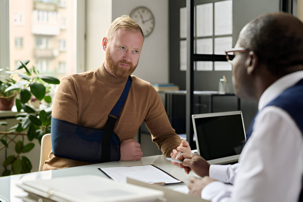 Man with arm in sling meets with lawyer to discuss potential personal injury claim in Las Vegas.